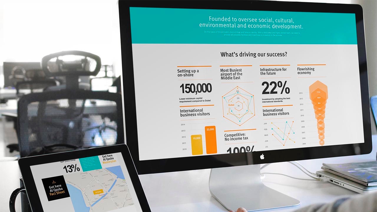 A woman is using a laptop and a tablet at her desk on a corporate website.