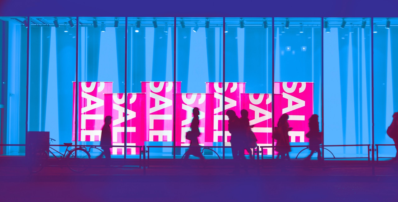 A group of people standing in front of a neon sign.