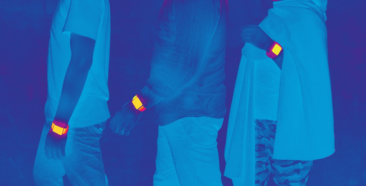 A group of people wearing Apple Watches standing in front of a blue background.