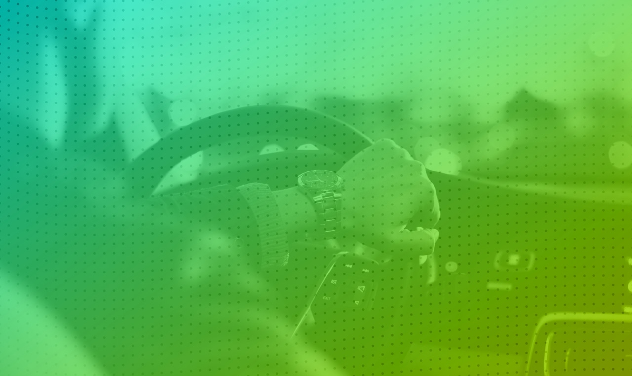 A person driving a car with a green and blue background.