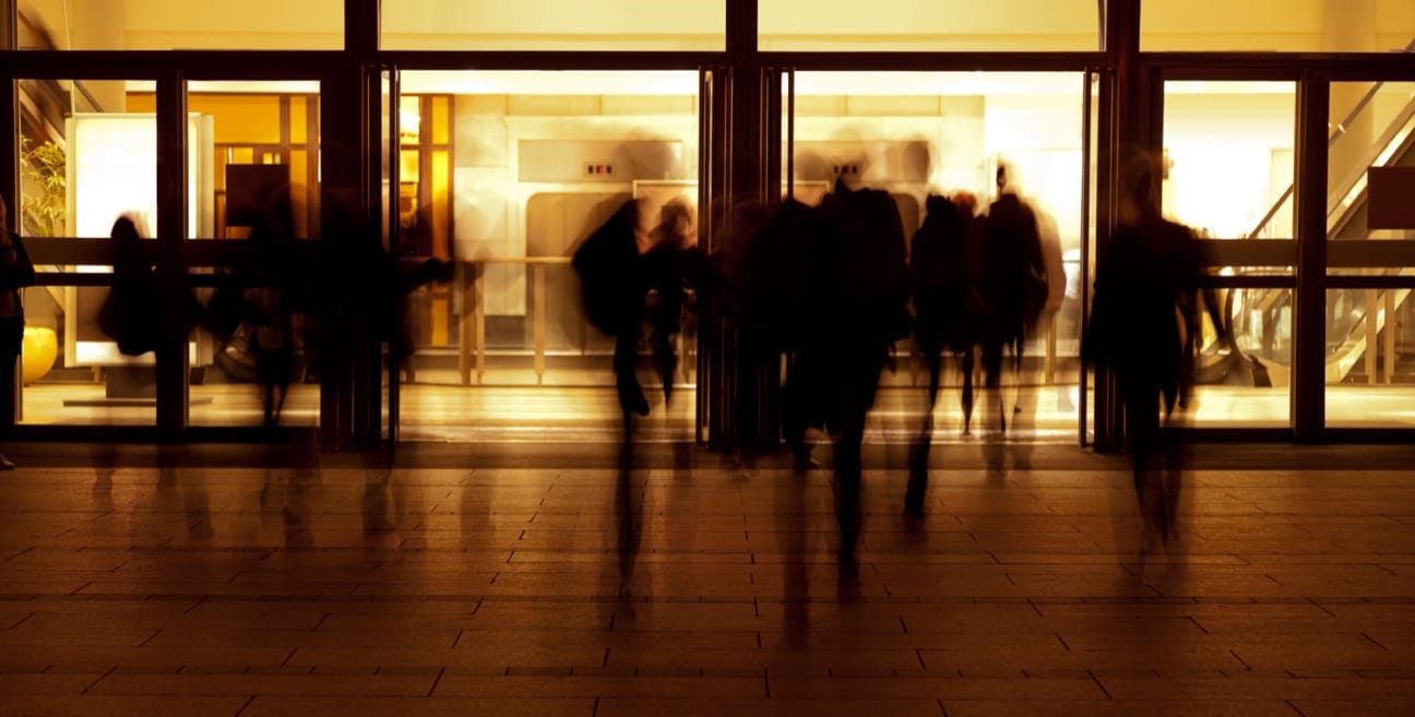 A group of people walking in front of a door.
