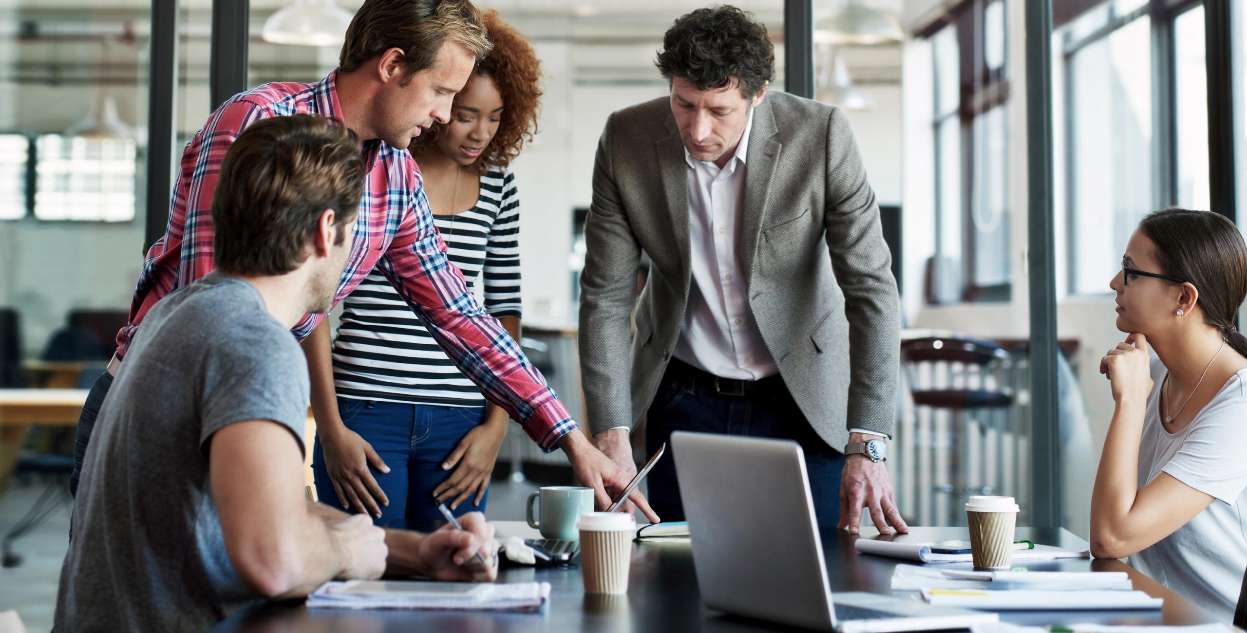A group of people sitting around a table in an office.