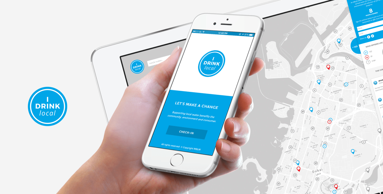 A woman with a smartphone in her hands and a tablet in the background, both with the I DRINK LOCAL app.