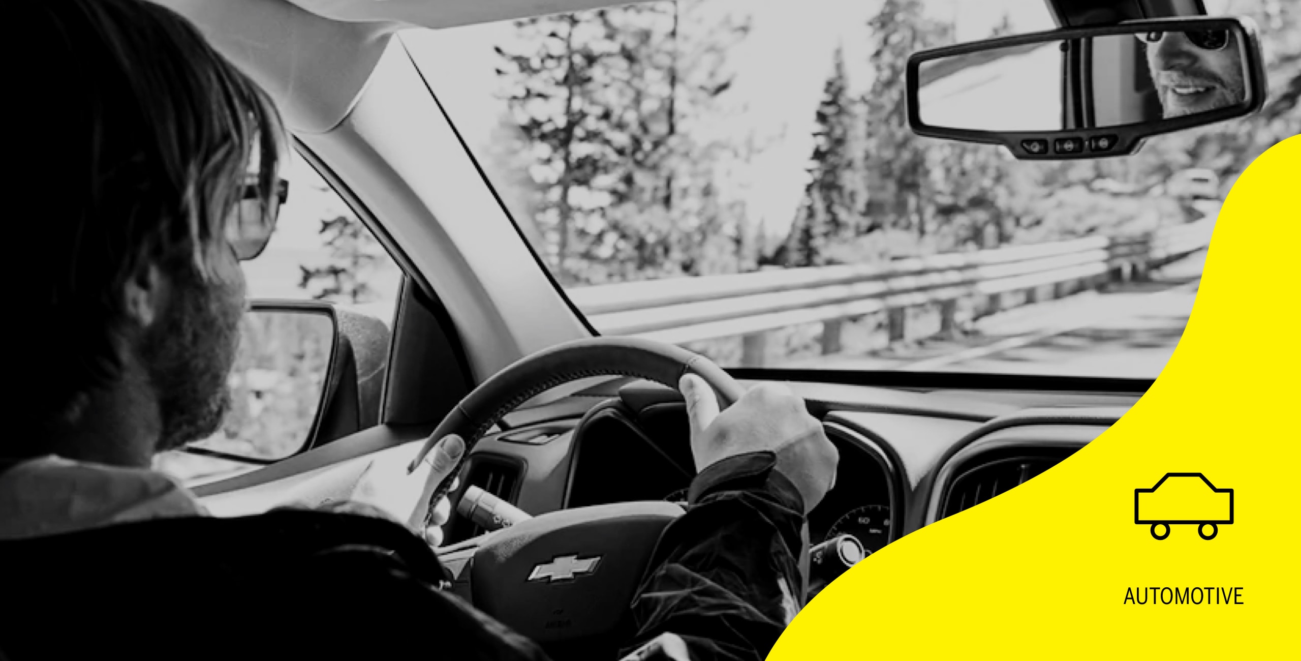 person in a car driving with automotive log on the side of image