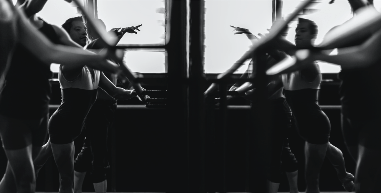 A group of ballet dancer practicing in front of a mirror