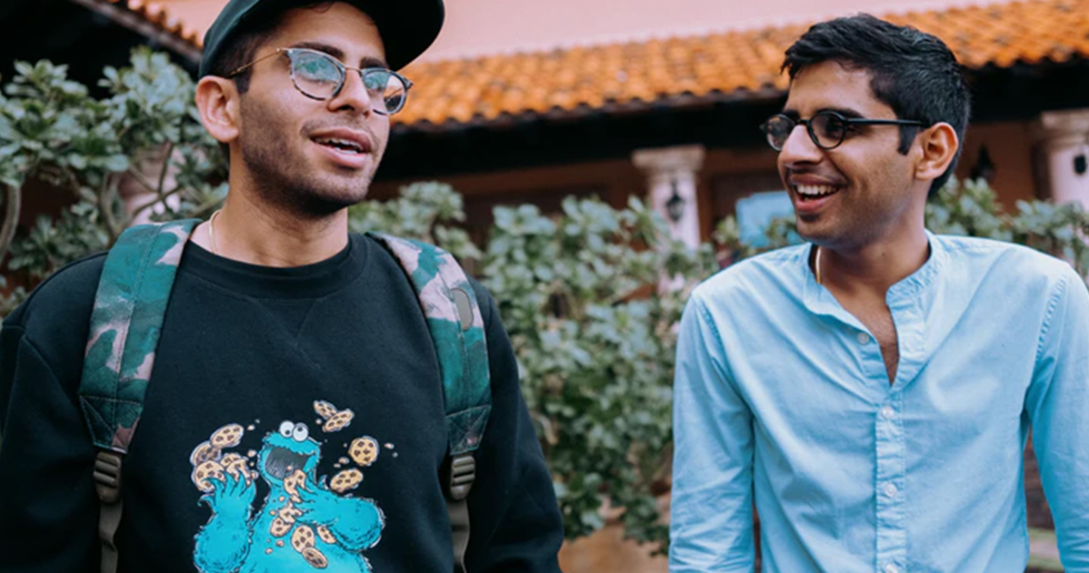 Two men are standing in front of a building.