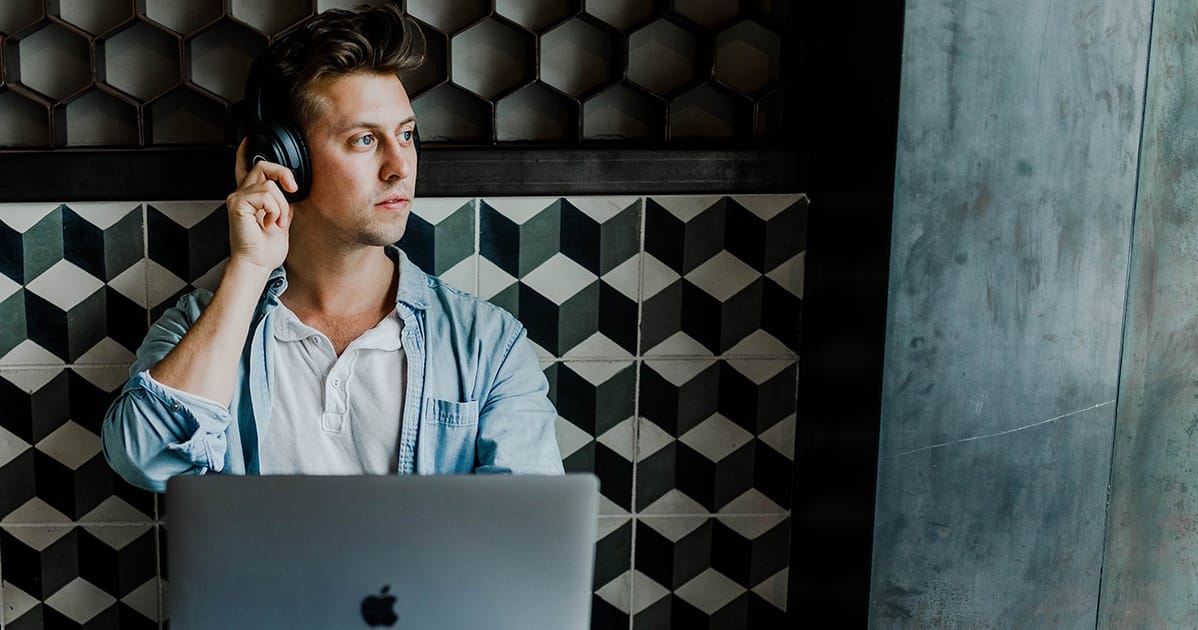 A man on a laptop talking on the phone.