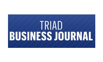 The triad business journal logo on a blue background.