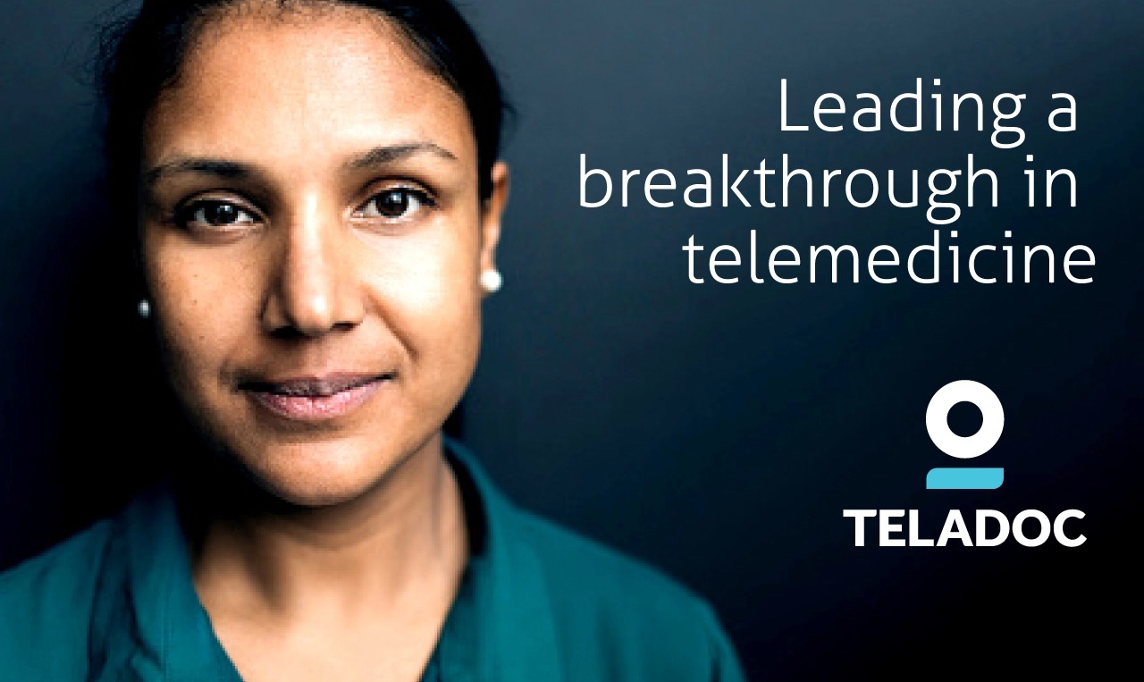 a woman in a green medical scrubs is looking at the camera.