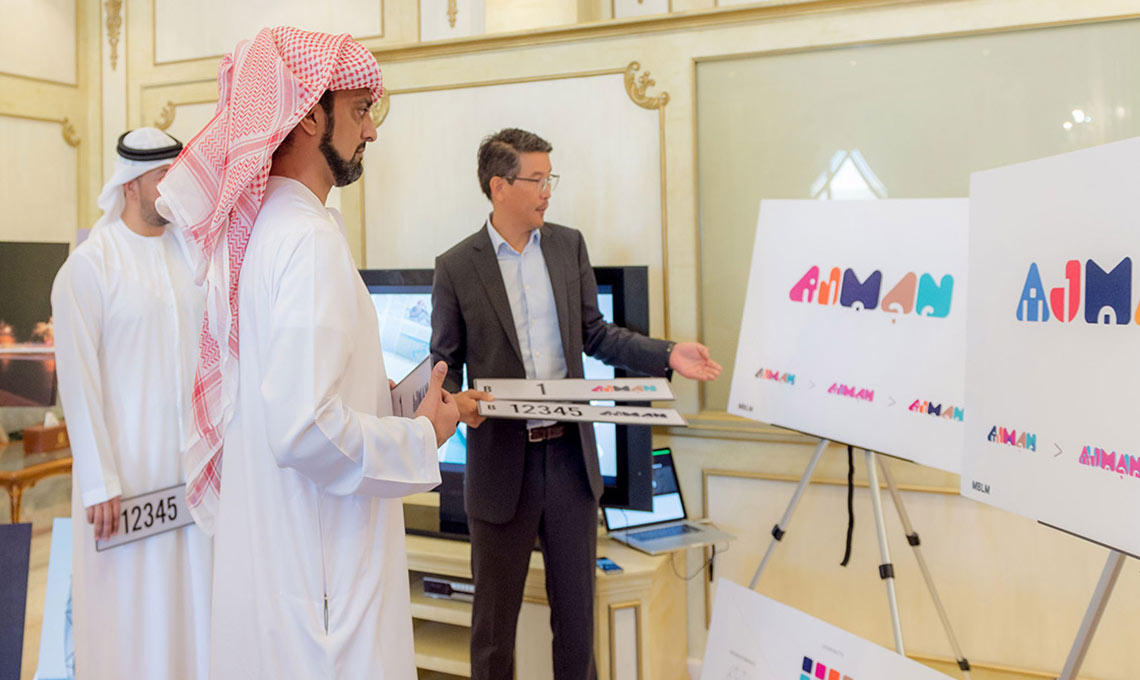 Two men standing in front of a board with a logo on it.