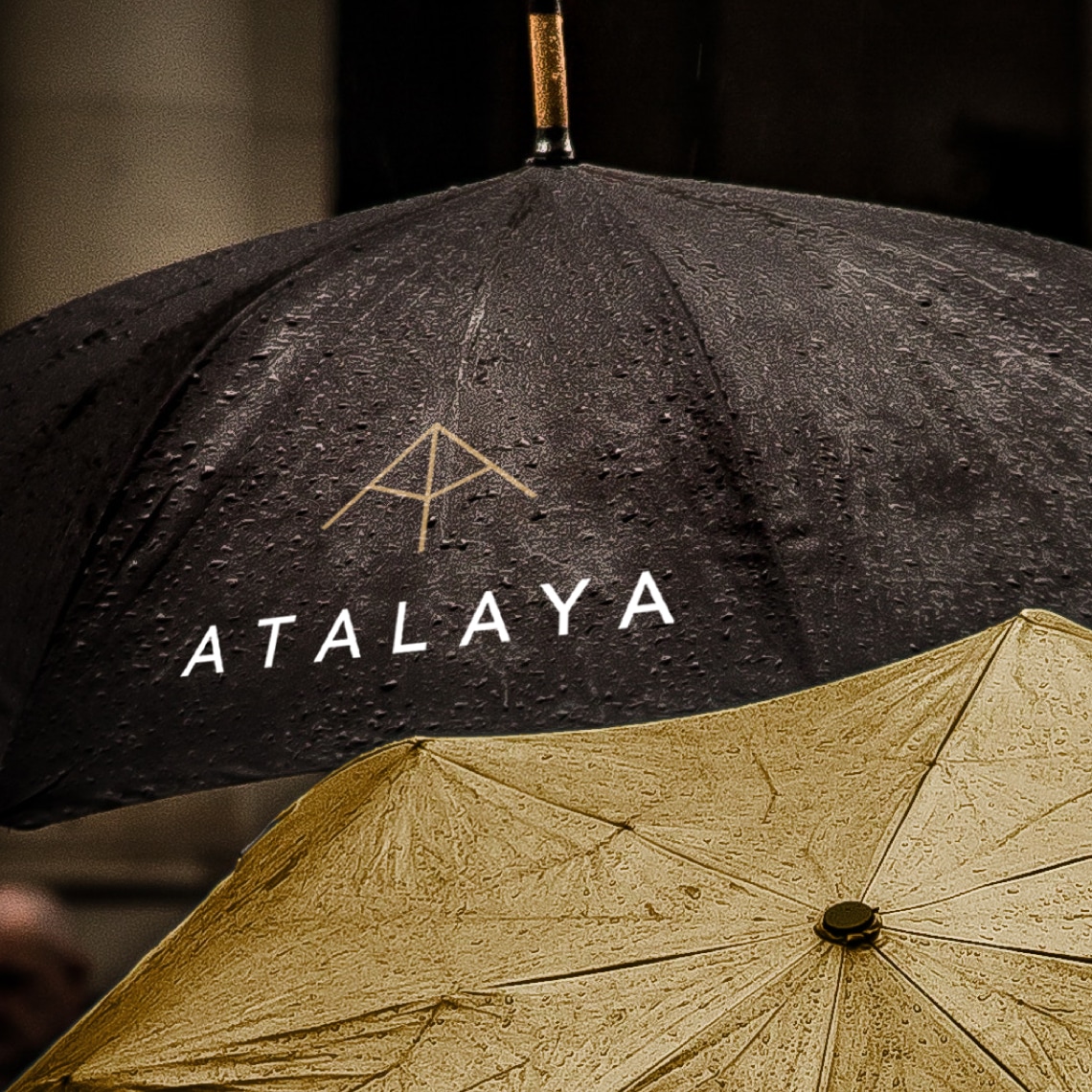a black umbrella branded with the Atalaya logo