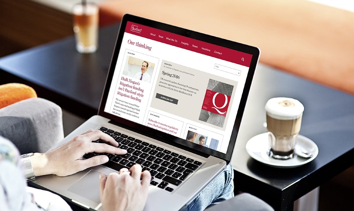 A person using a laptop with a brand logo on it.