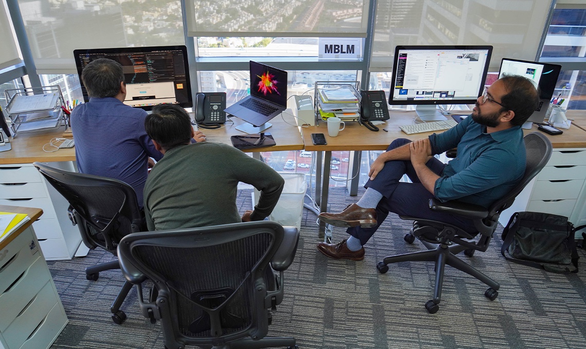 A group of people sitting at desks in an office.