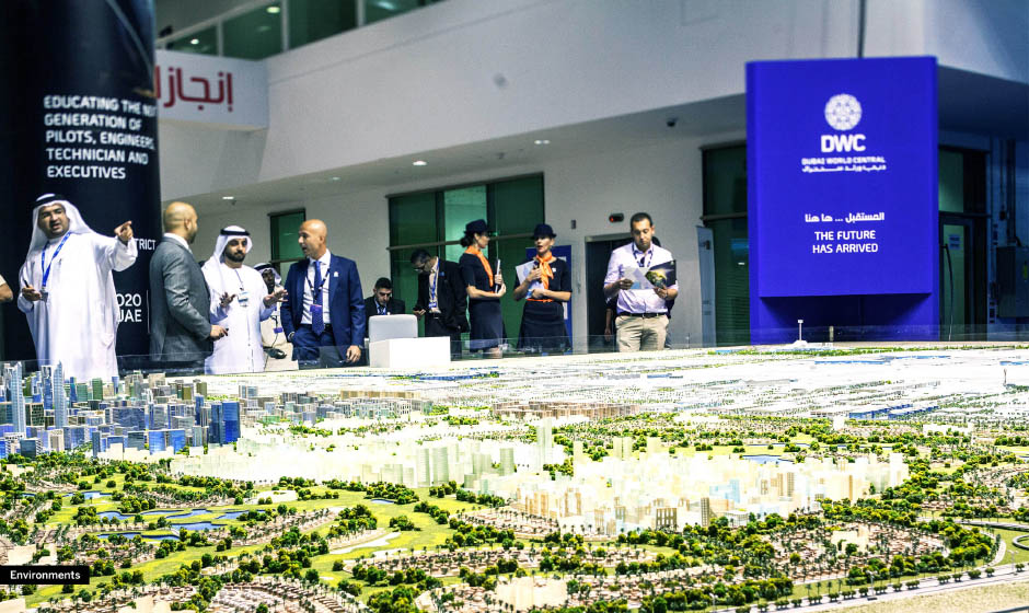 People observing a city model at an event.