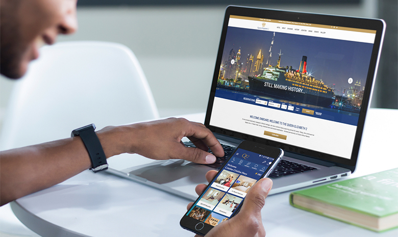 A mobile phone and a laptop showing the website designed for QE2