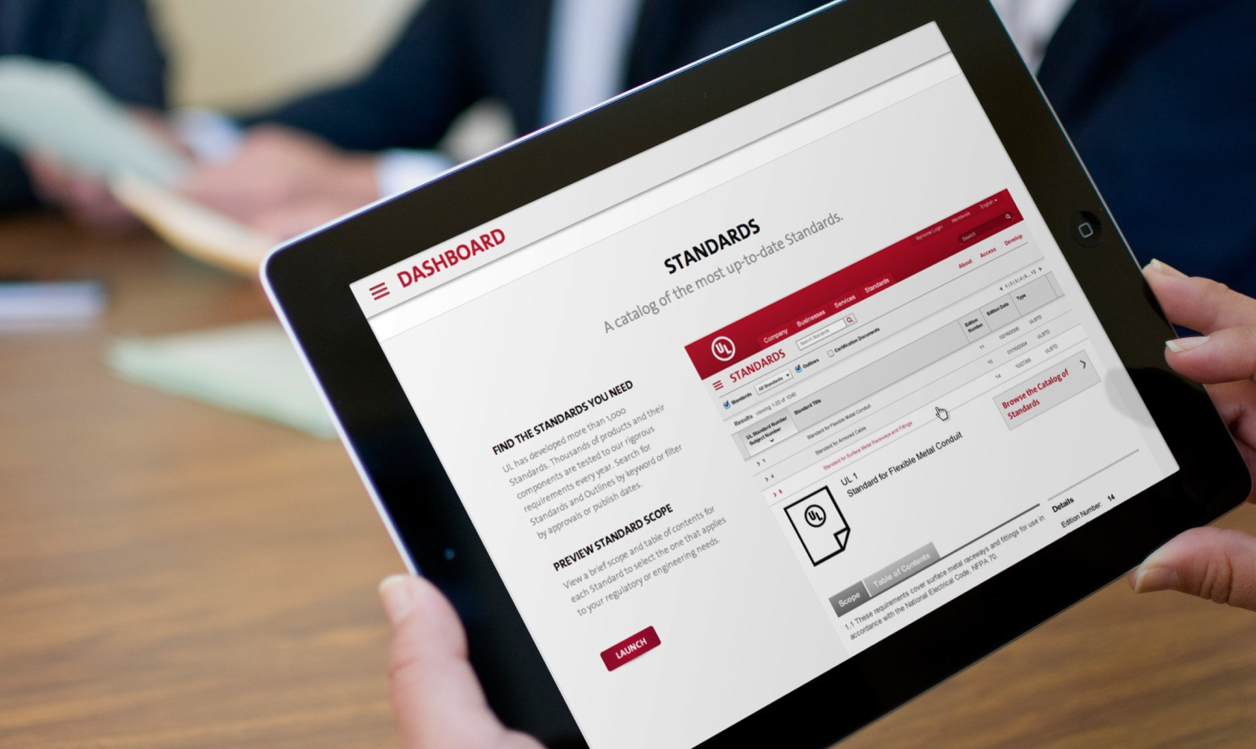 A person holding an ipad with a red and white screen.