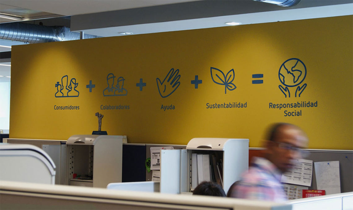 A man walks past a yellow wall in an office during brand repositioning.