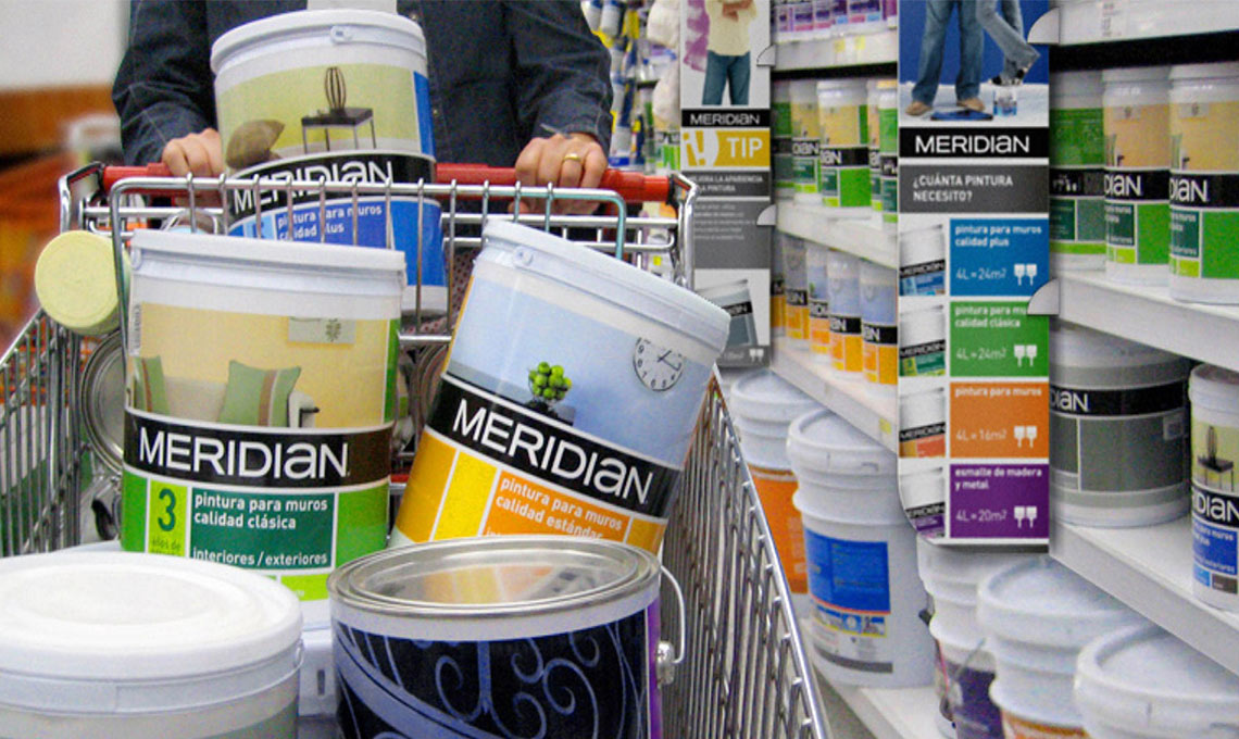 A man is pushing a shopping cart full of paint while passing through Meridian.