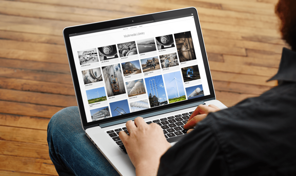 A man with a laptop searching an image bank website