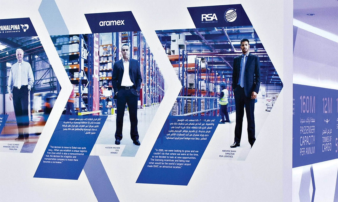 A large wall display showcasing an environmental design with people in front of it.