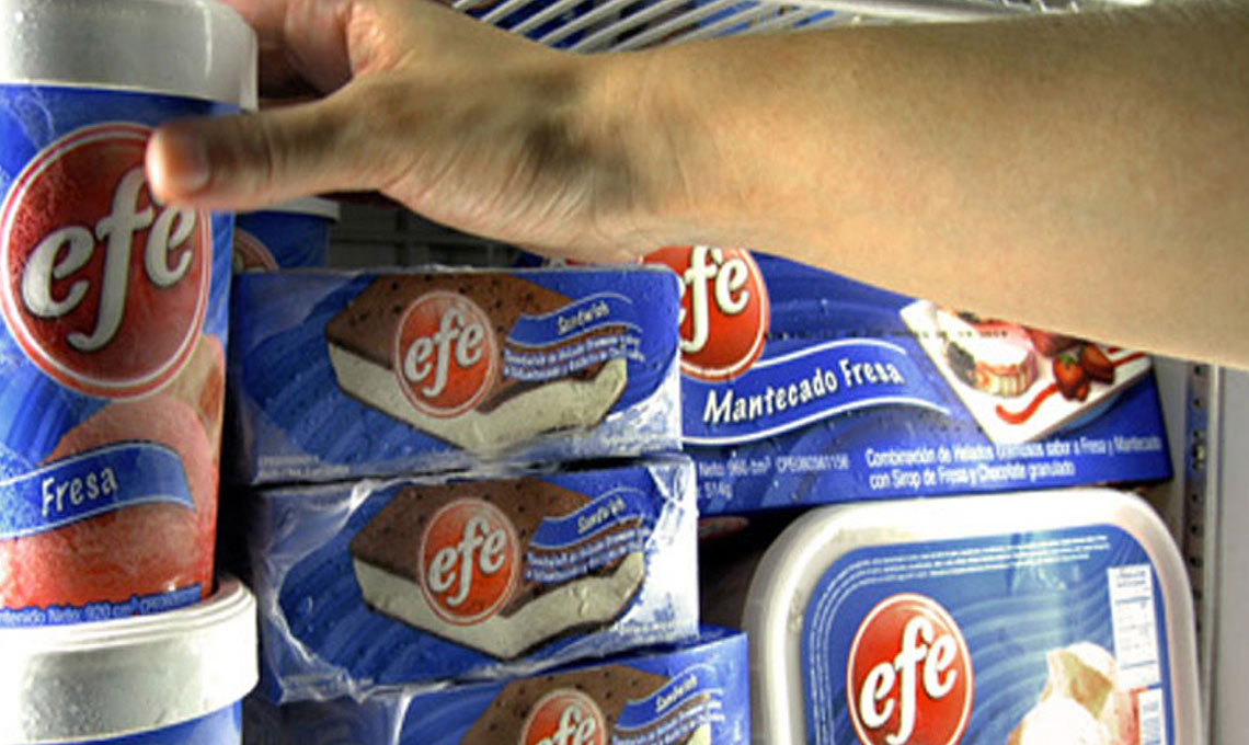 A person is filling a container with ice cream.