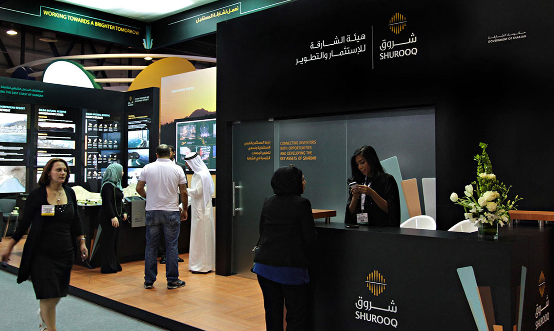 A group of people standing in front of an exhibition booth.