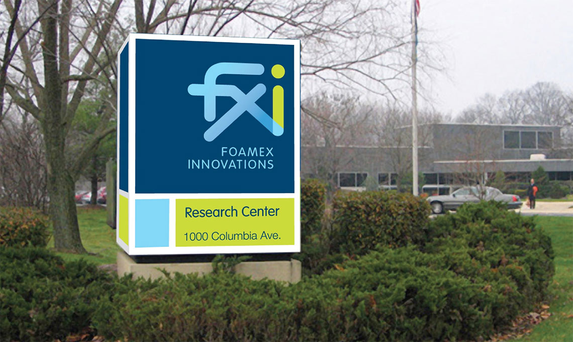 a sign with the brand identity developed for FXI in front of a building