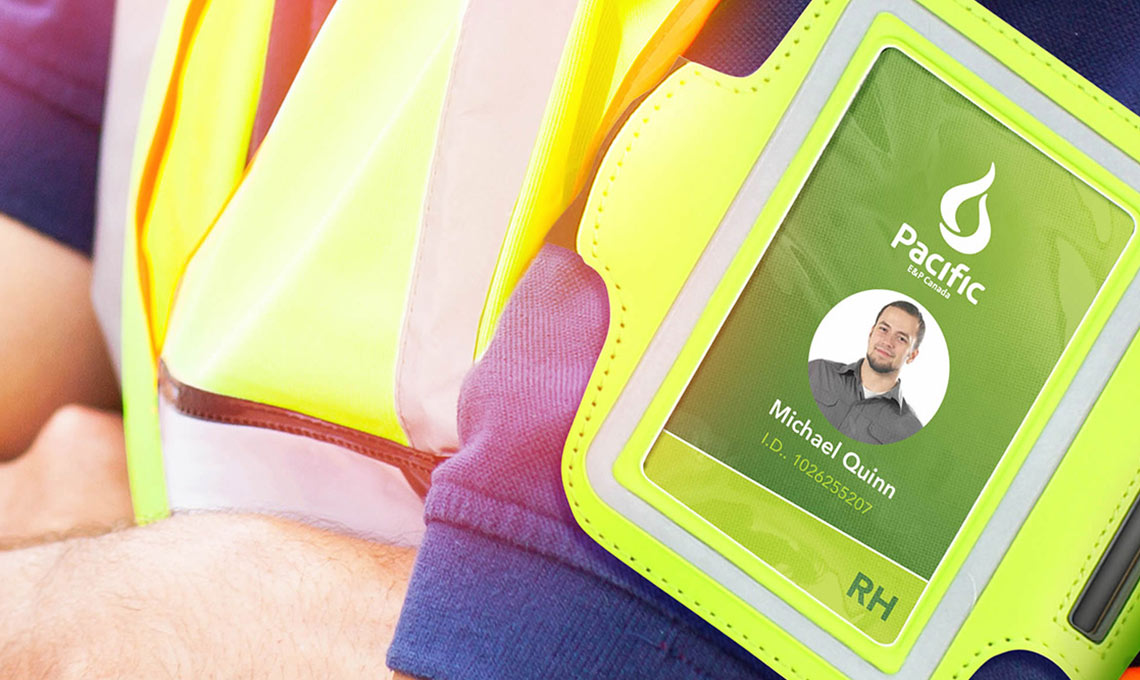 A man is wearing a branded vest with an ID card on it.