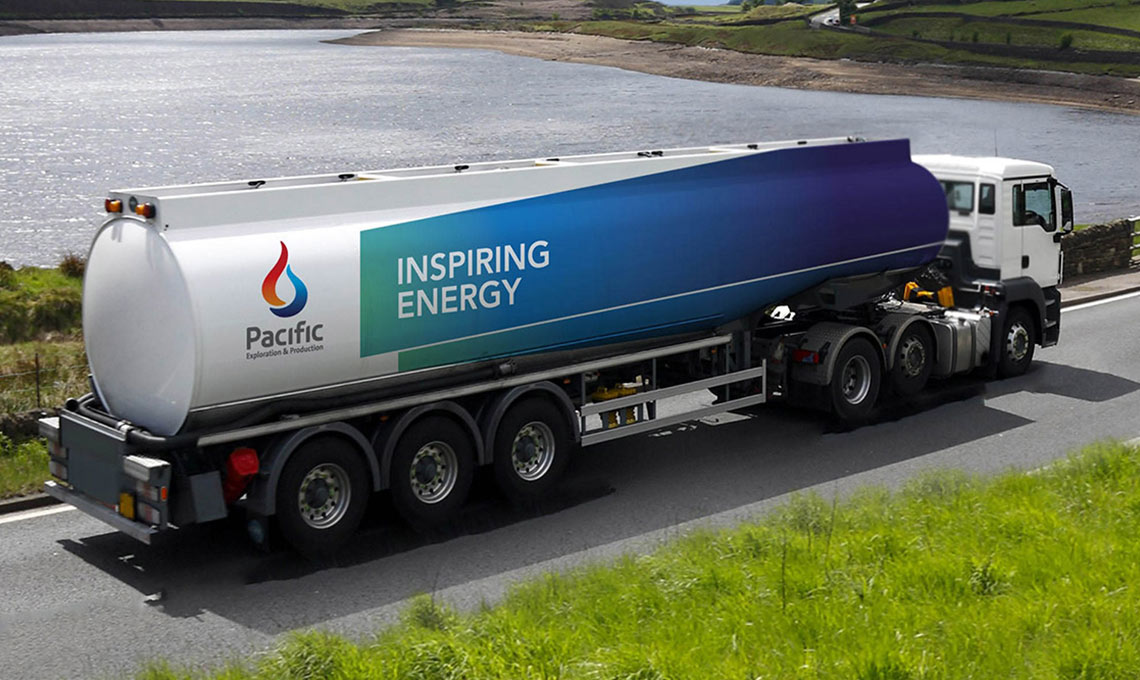 A tanker truck repositioning its brand near a body of water.