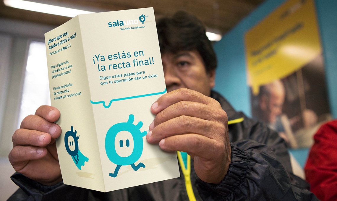 A man holding up a brochure with a blue background, redefining the visual experience.