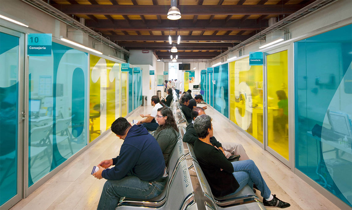 A group redefining the experience of seeing, sitting on benches in a hallway.