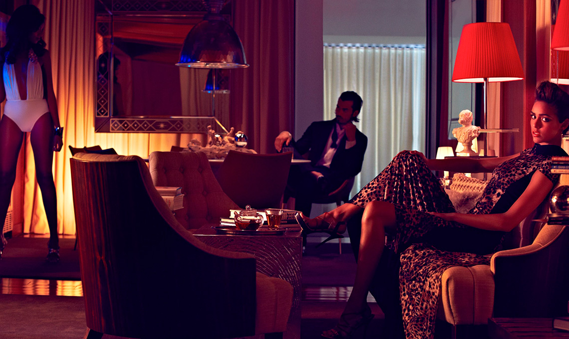 A woman in a leopard print dress sitting on a chair.