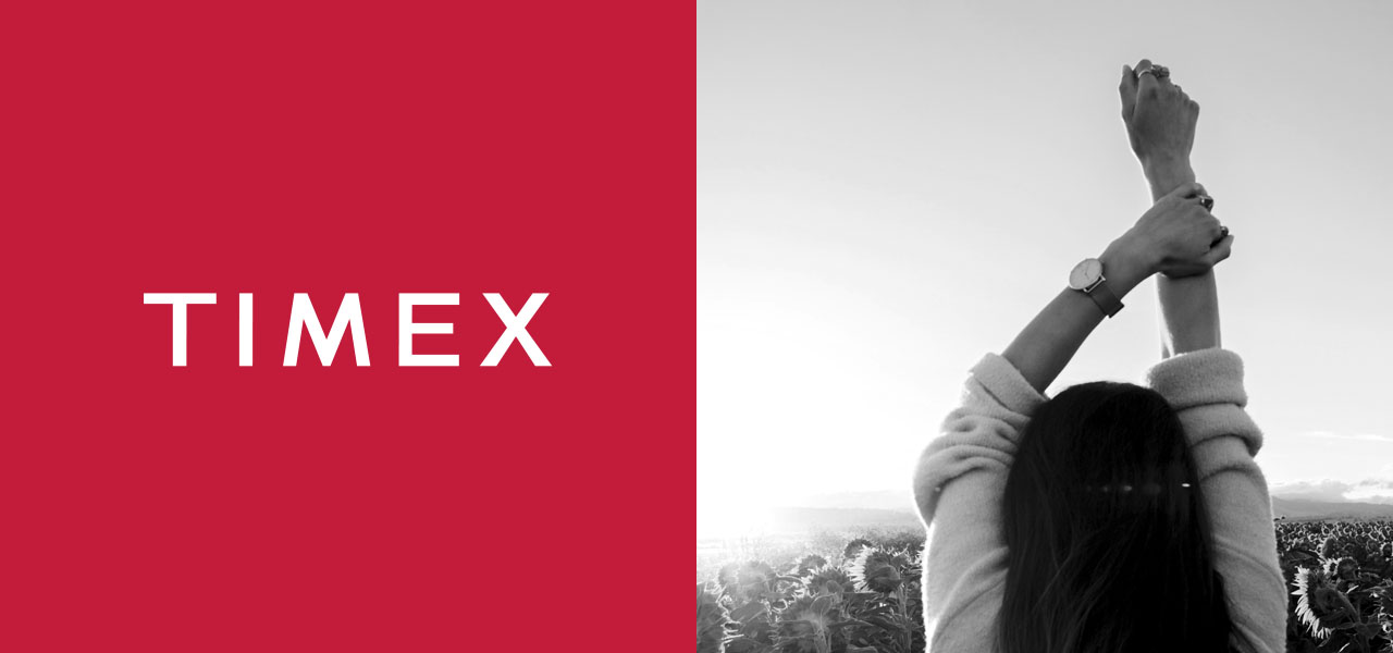 A woman showcasing the American Icon Timex with her arms up in the air.