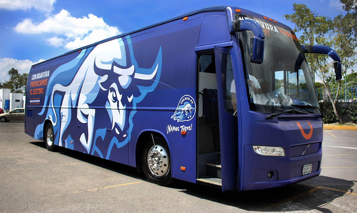 A blue bus with a new vision parked in a parking lot.
