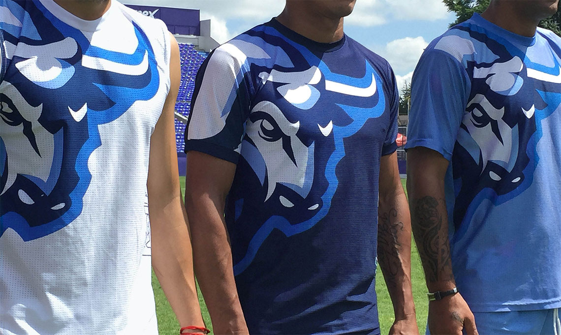 Three men in blue and white t-shirts standing together with a new vision.