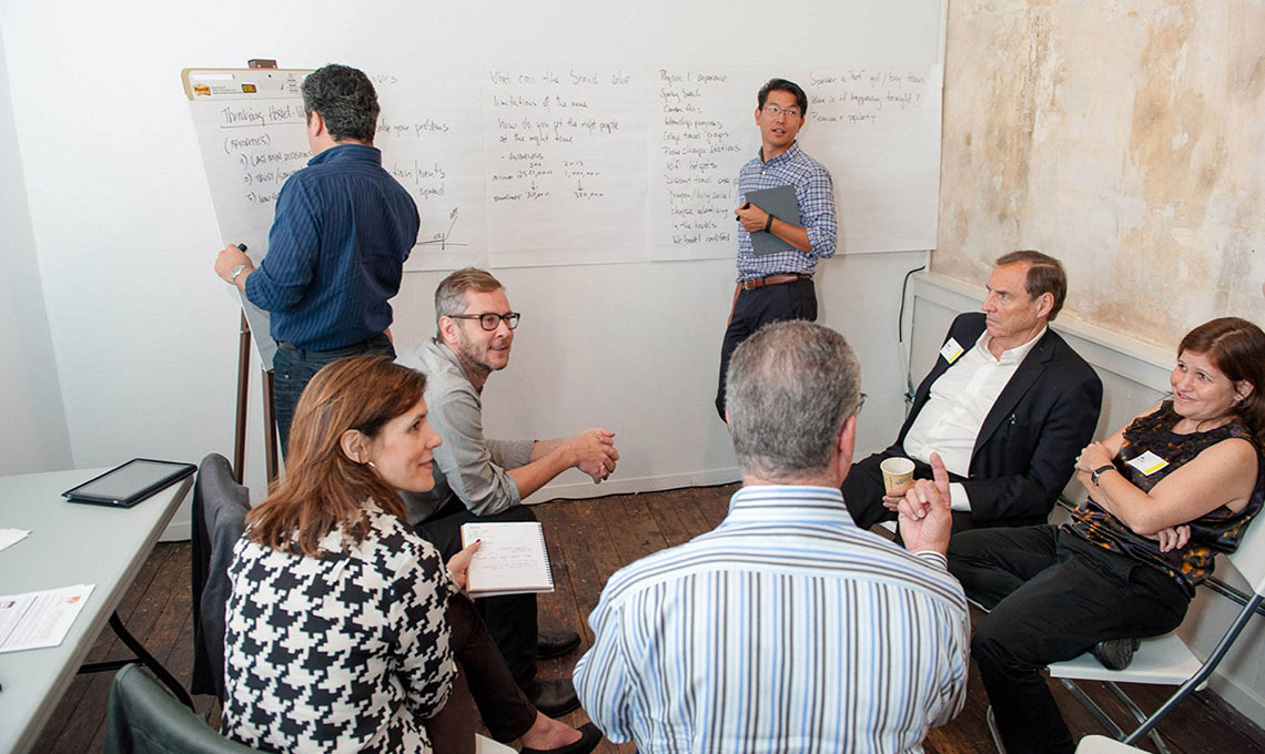 A mobile app with a group of people sitting around a whiteboard.