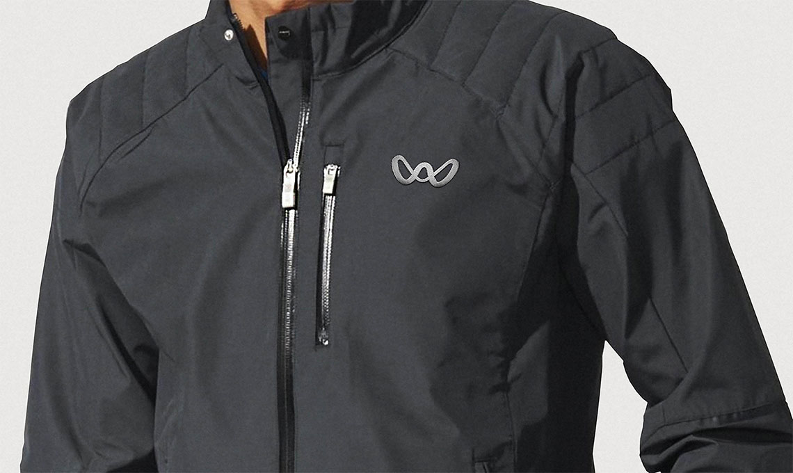 A man boldly wears a black jacket with a logo on it, generating value.