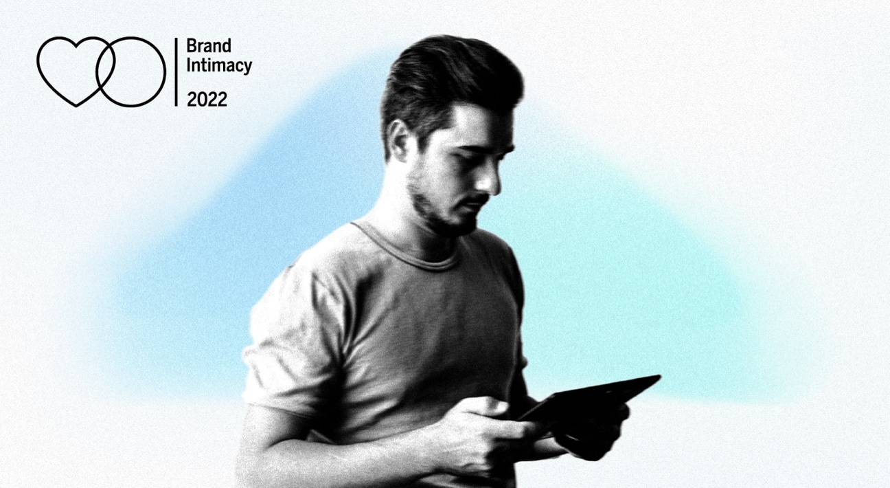 A man is holding a tablet and looking at it.