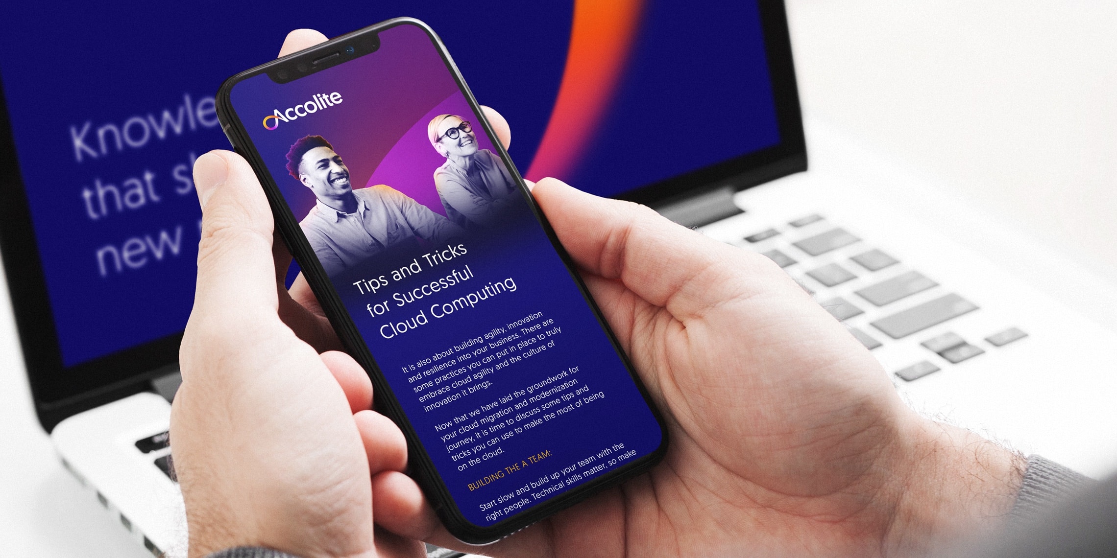 A person holding a smartphone and a laptop in the background with a new accolite website on it.