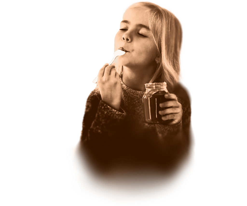 a girl eating with a spoon from a jar