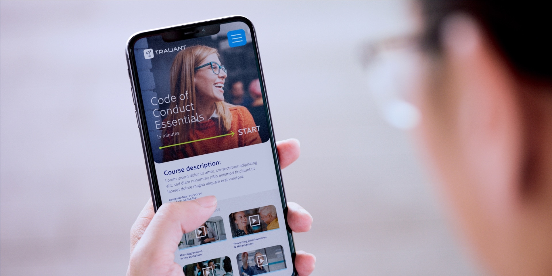 A person holds a smartphone with the new Traliant website.