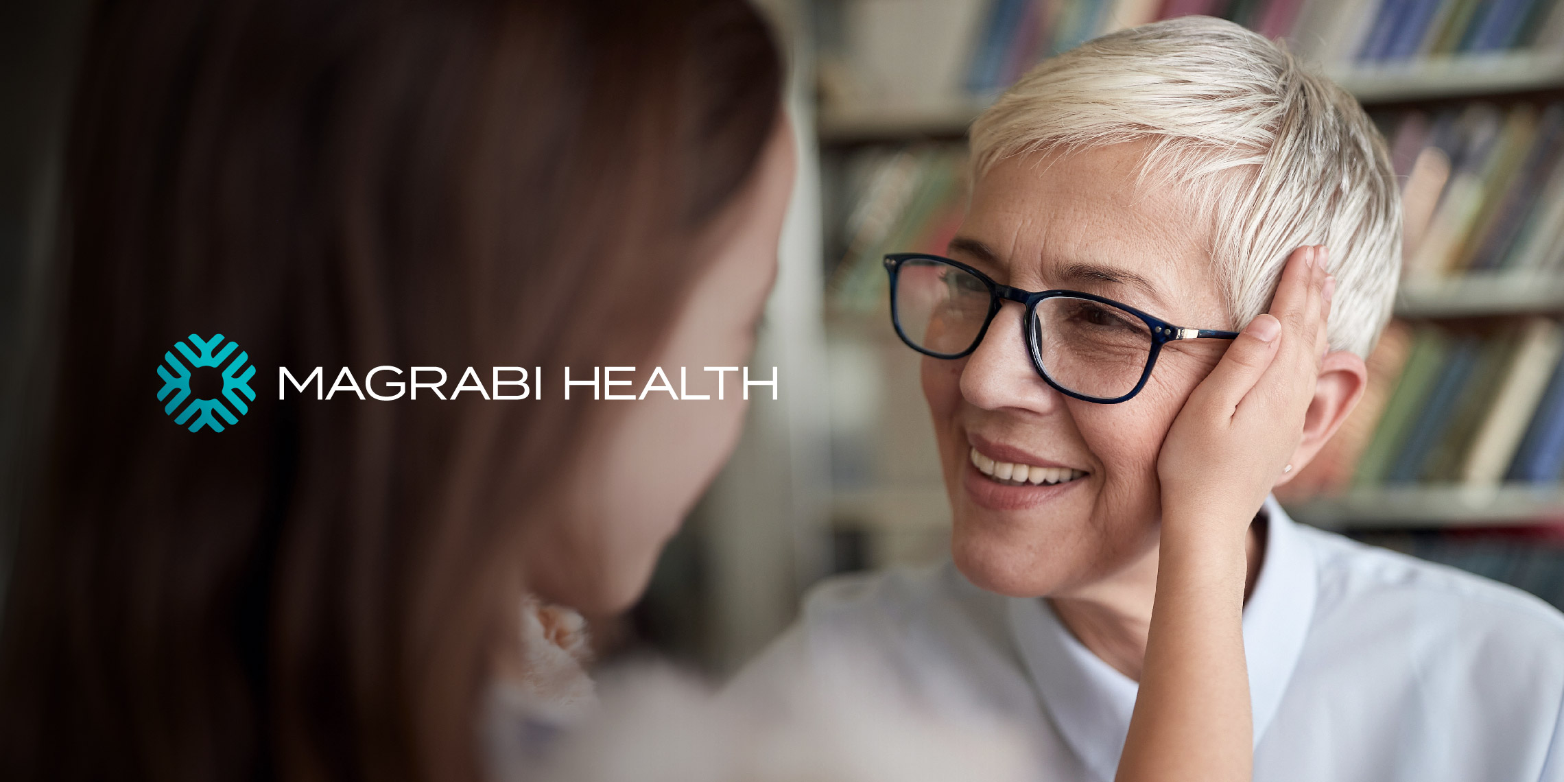 The Magrabi health logo with the watermark symbol, designed by OMNRAE over a picture of a old lady wearing glasses, honoring the brand’s ophthalmology legacy.