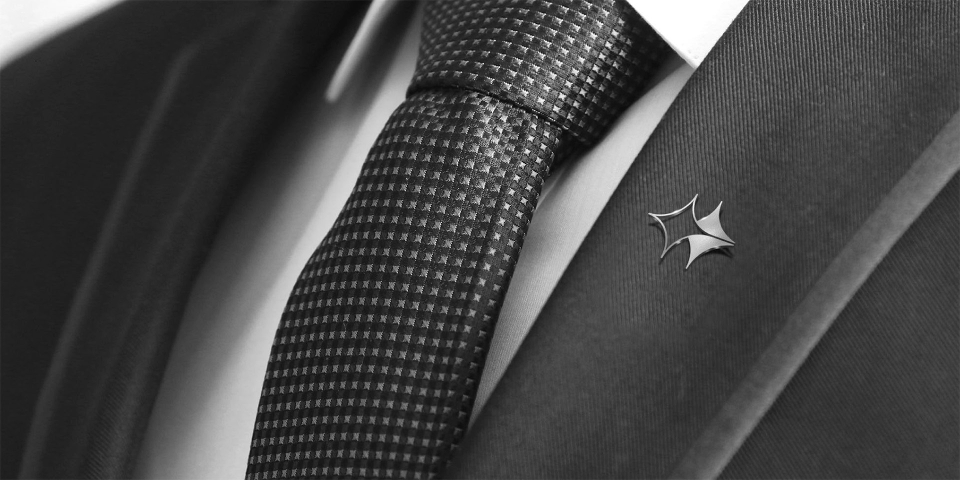 Close-up of a Senwan shirt pin featuring the dual star design symbolizing heritage and forward momentum. This logo serves as a discreet yet powerful symbol of their brand identity.