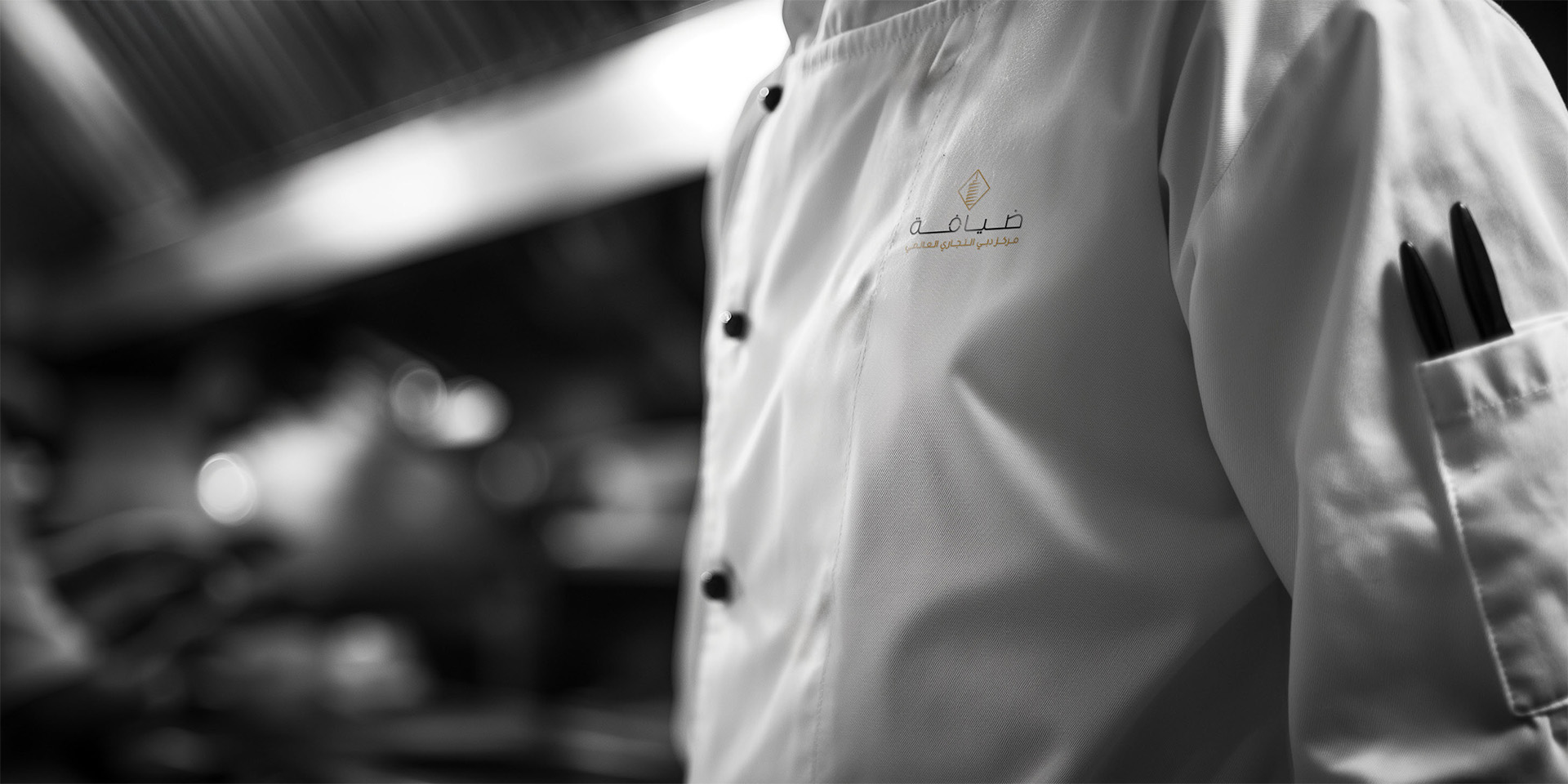 Chef wearing a DWTC Hospitality uniform featuring the new brand logo.